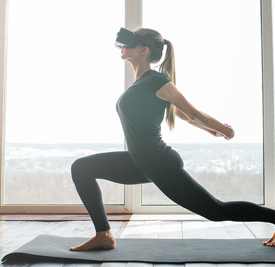 young woman doing yoga with a virtual reality headset