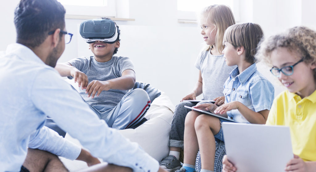 Kids with their teacher trying virtual reality and learning