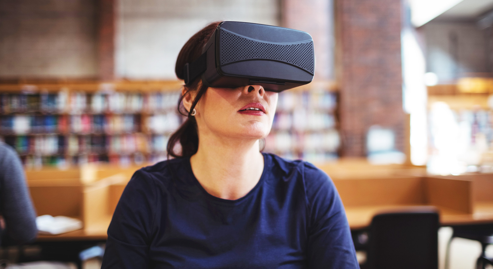 Mature student using virtual reality headset in public library