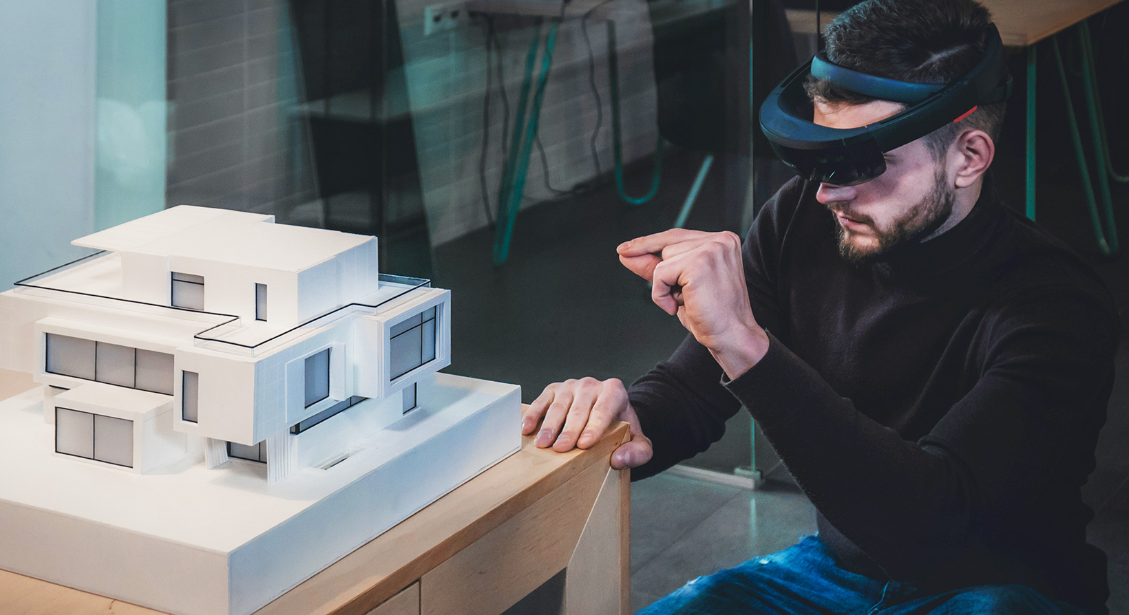 male architect working on a private house project in the office using augmented reality glasses