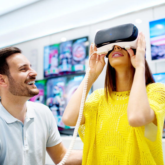 Young couple trying on virtual reality headset in a store