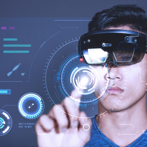 Young Man wearing Hololens pressing virtual buttons on business charts