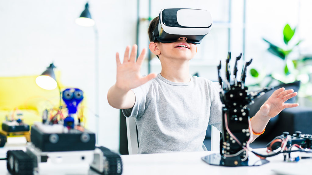 kid is using virtual reality for education and experimenting with robotic devices