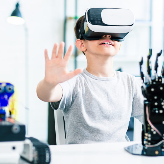 kid is using virtual reality for education and experimenting with robotic devices