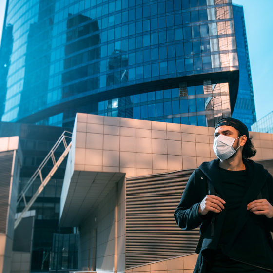 man in medical mask looking away from built environment in a post coronavirus world