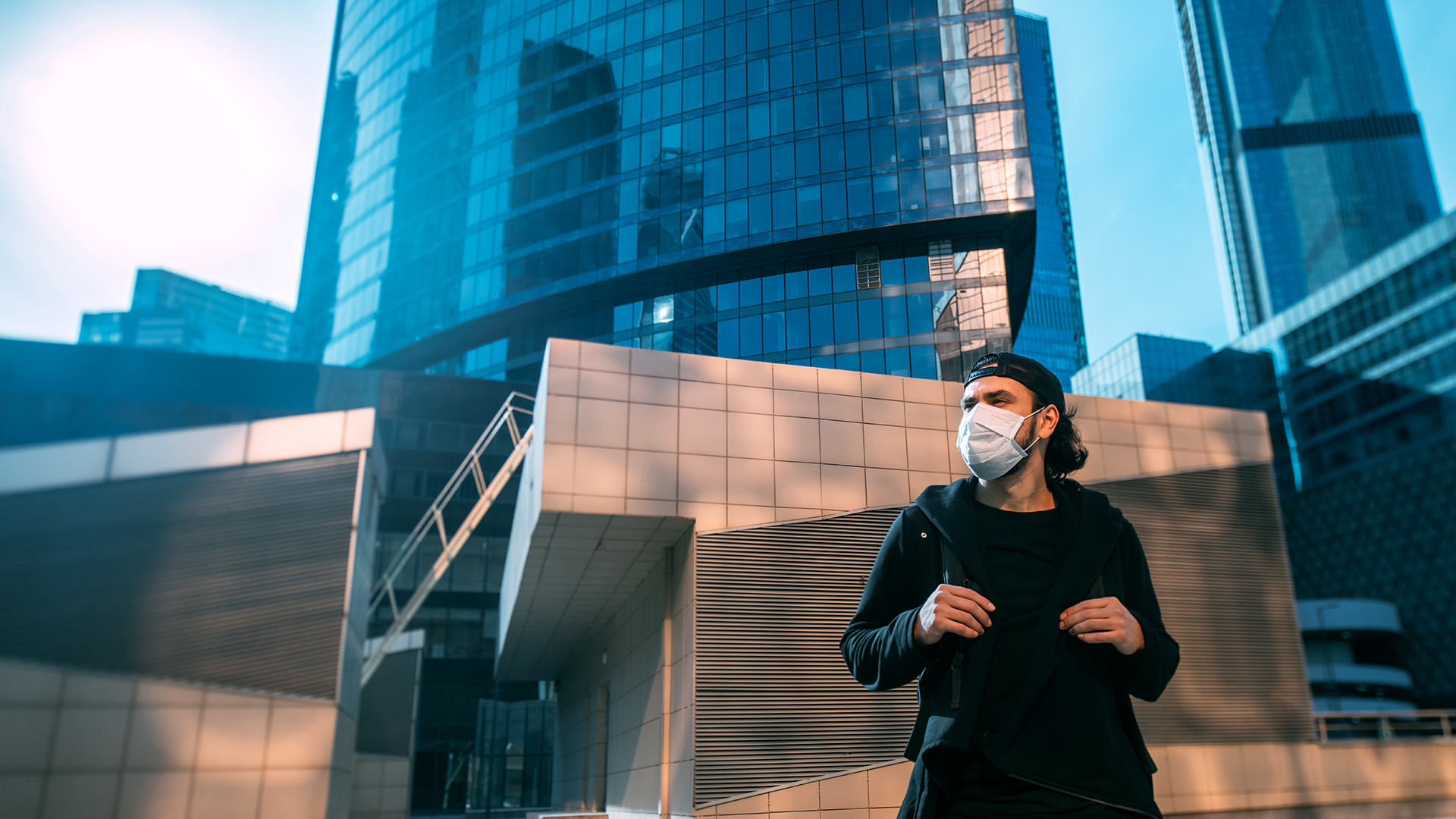 man in medical mask looking away from built environment in a post coronavirus world