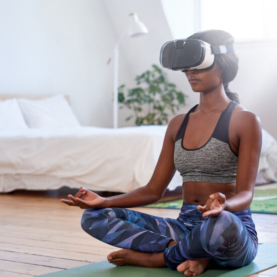 Woman meditating at home with VR goggles