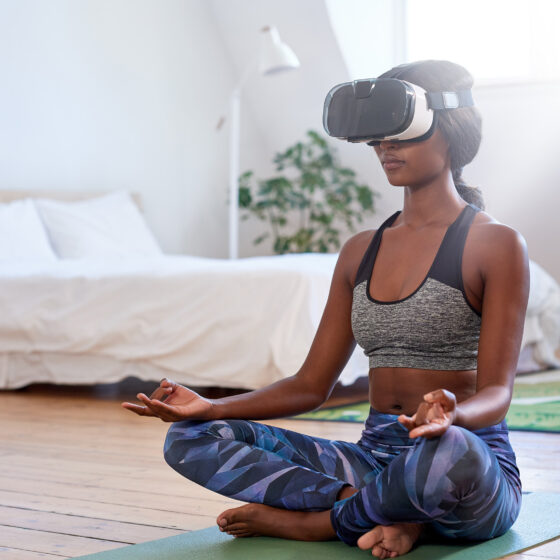 Woman meditating at home with VR goggles