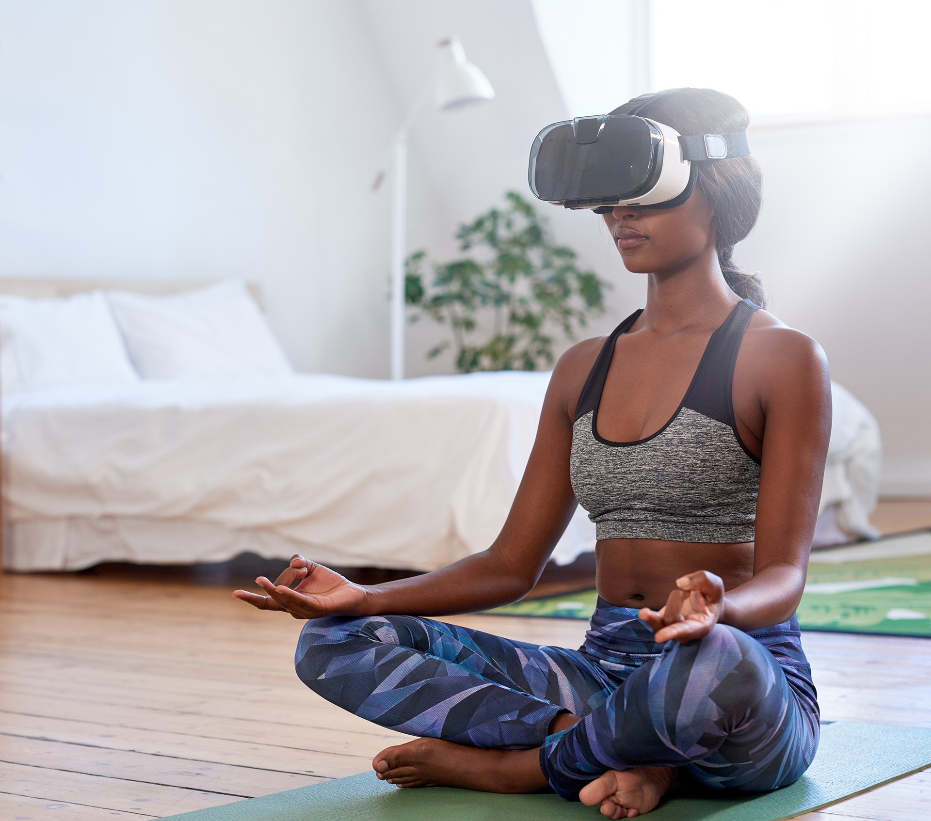 Woman meditating at home with VR goggles