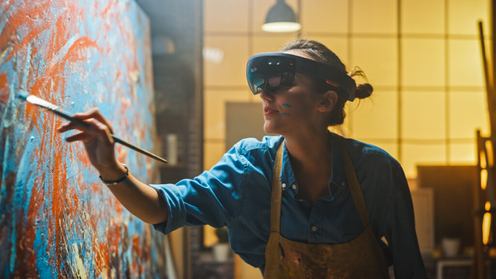 Talented Female Artist Wearing Augmented Reality Headset Working on Abstract Digital Painting, Uses Paint Brush To Create New Concept Art Using Virtual Reality Interface. High tech Creative Modern Studio